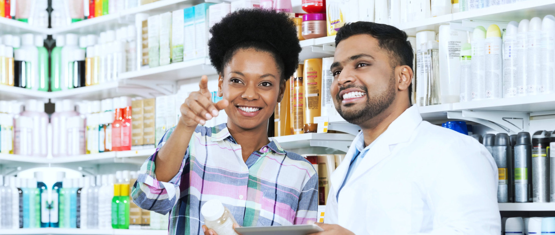 customer pointing at a pharmacy product requiring assistance with a pharmacist